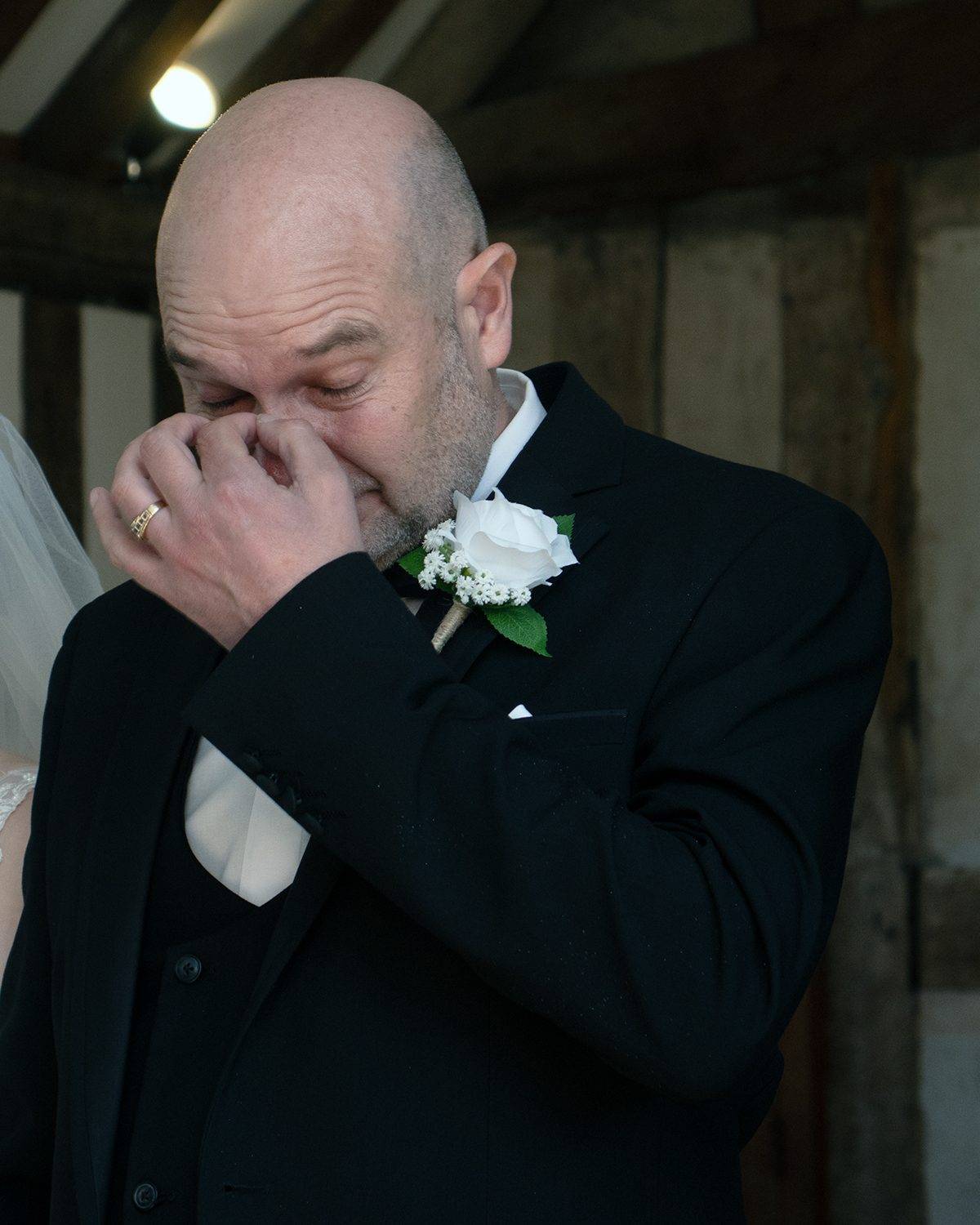 Checka's father wiping his eyes during the ceremony
