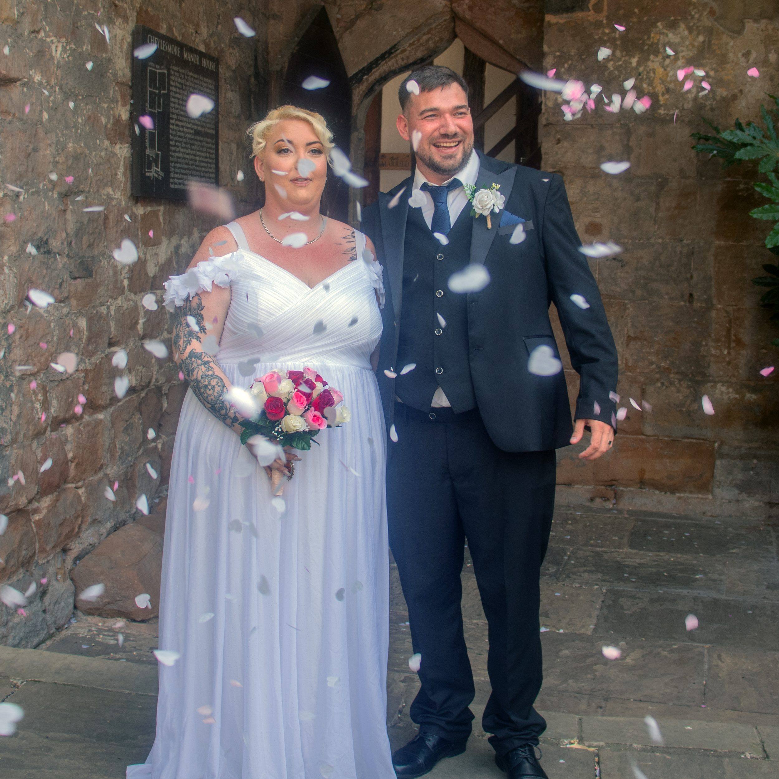 A bride and groom showered in confetti outside the church