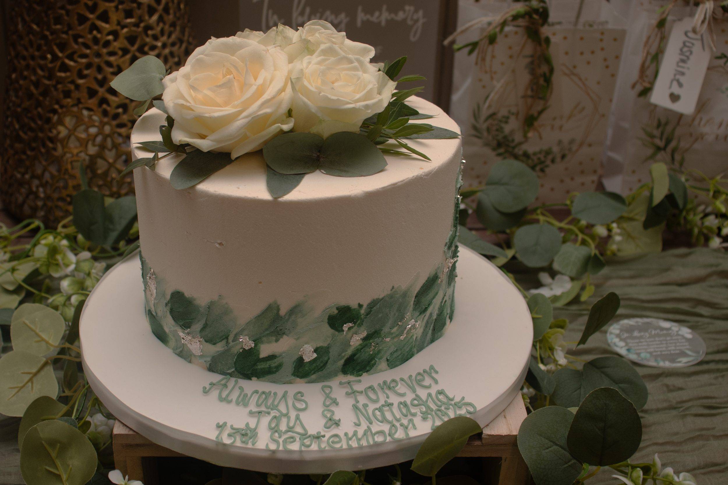 The wedding cake decorated with greenery