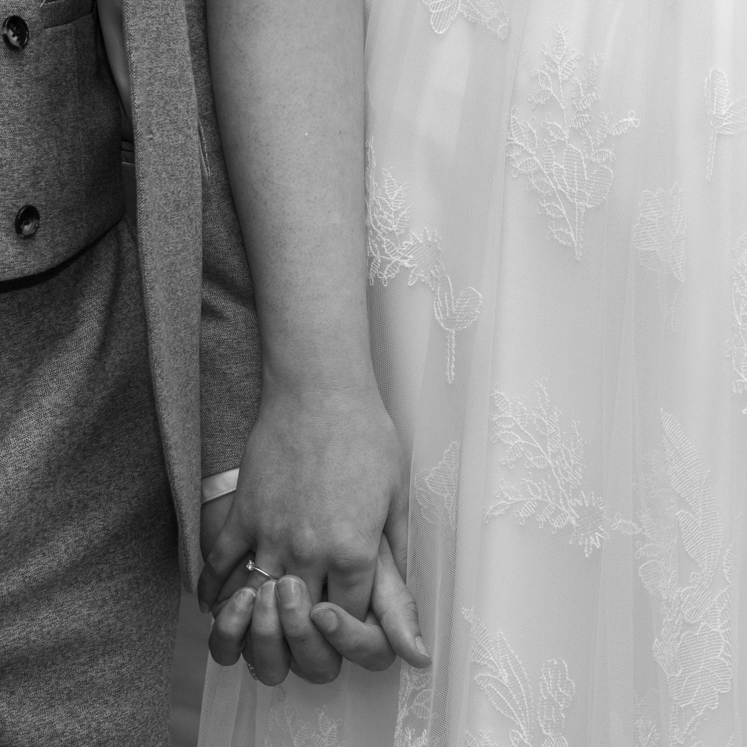 Black and white photograph of Luke and Alex holding hands