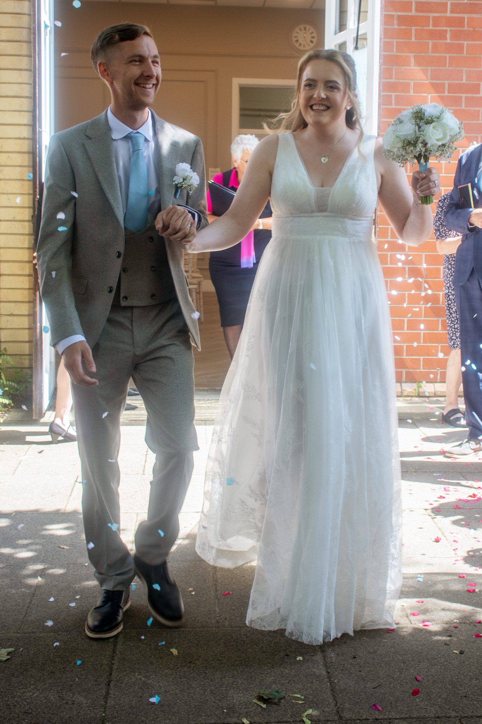 Alex walking out with her bouquet after the ceremony
