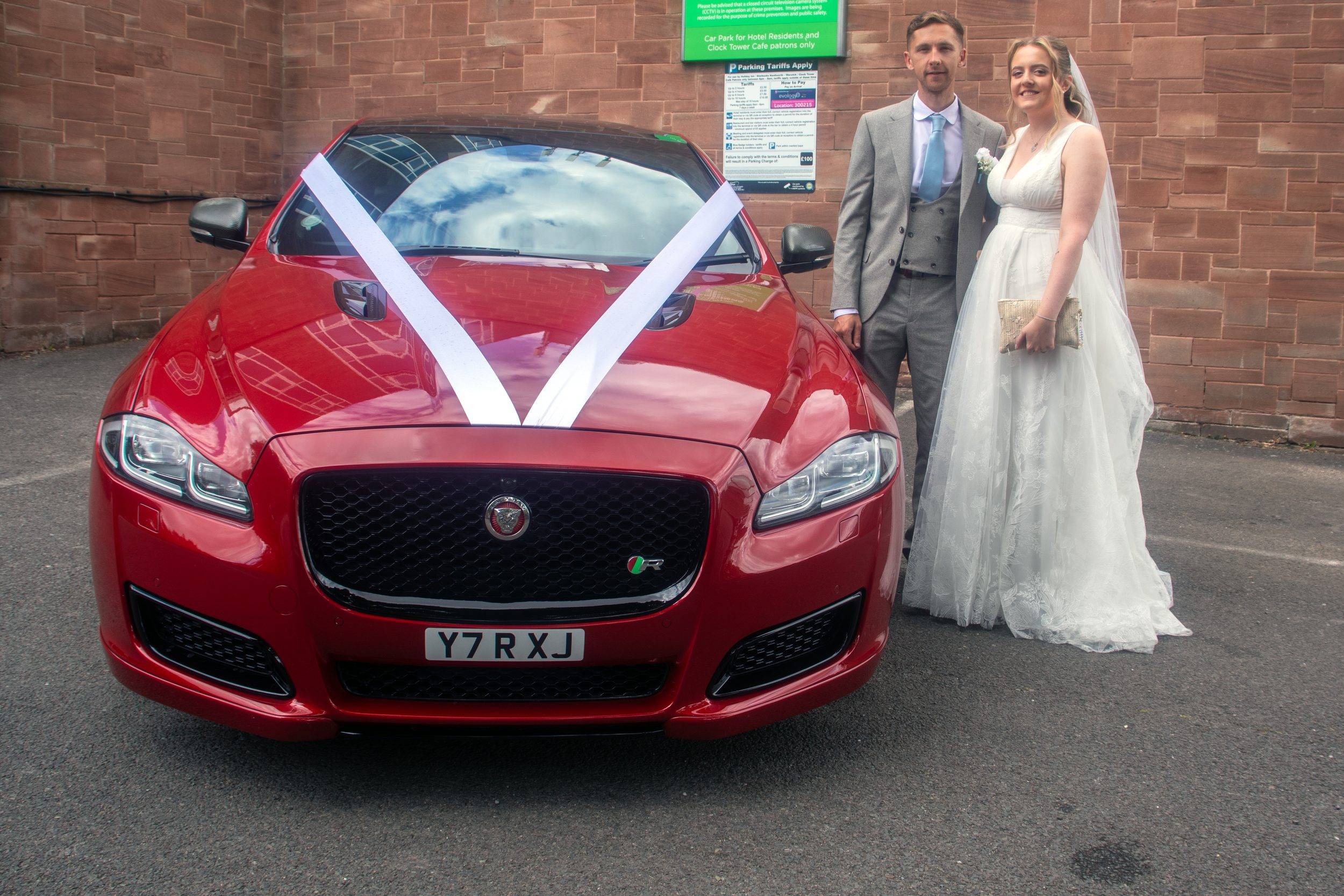The red wedding car outside the venue