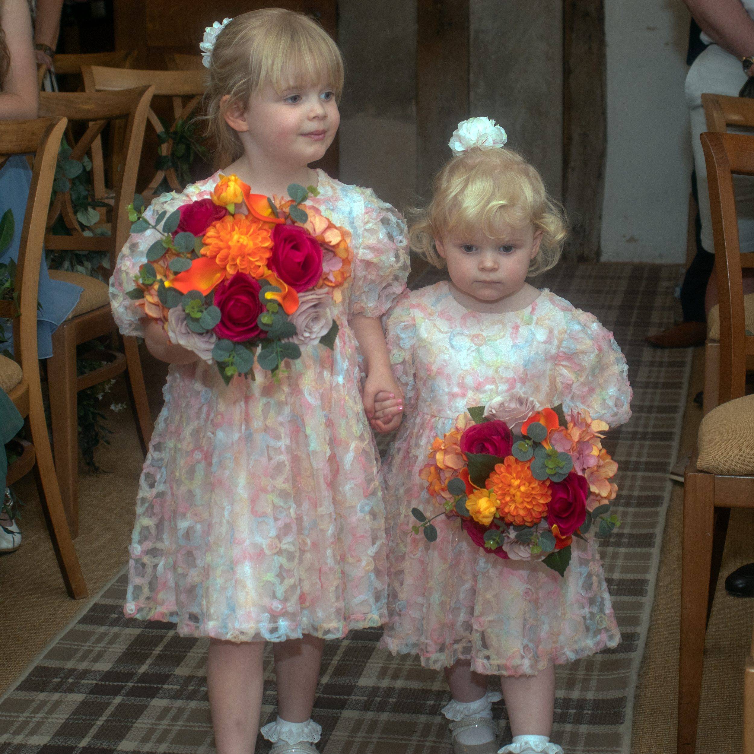 Rhiann's daughters walking down the aisle carrying flowers