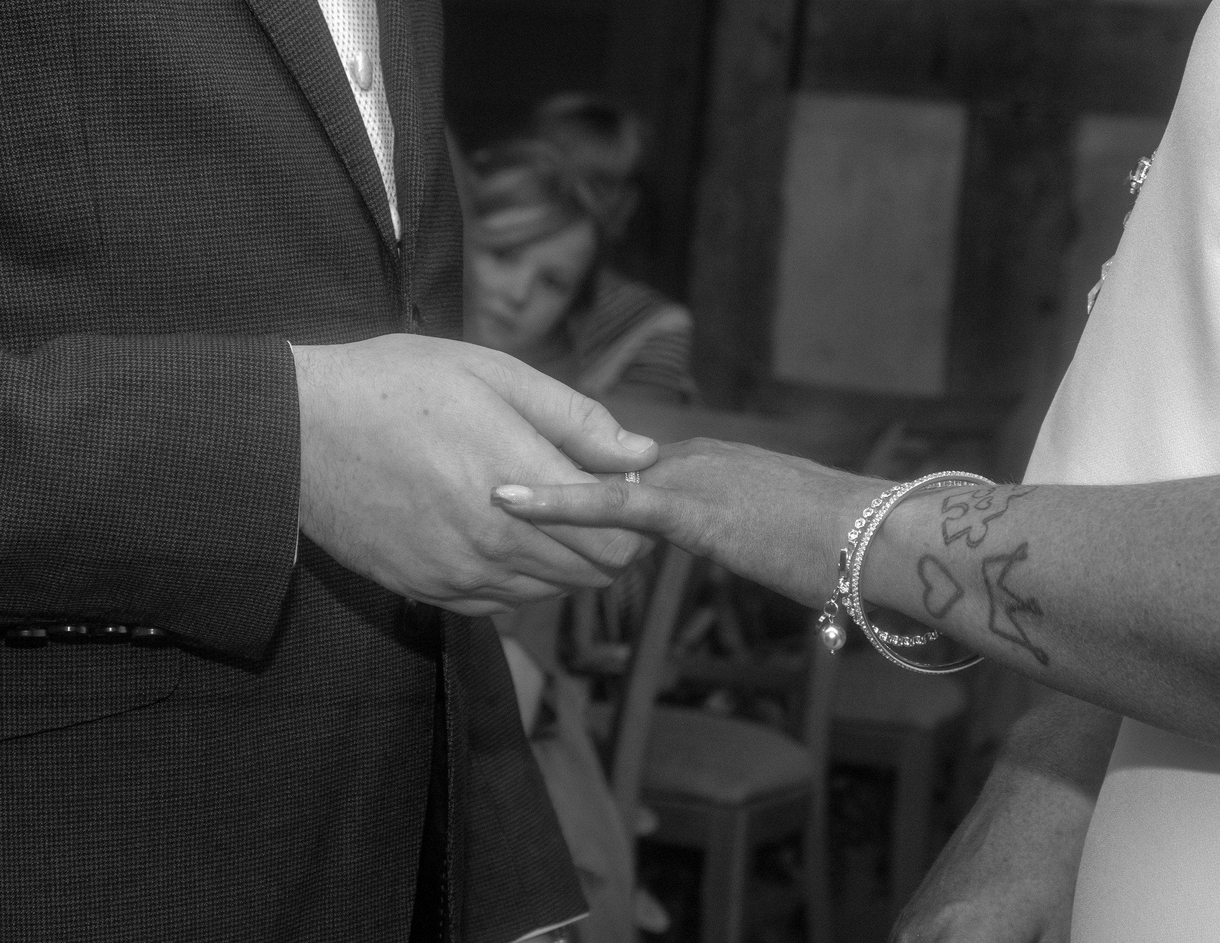 Black and white photograph of the ring going onto Rhiann's finger