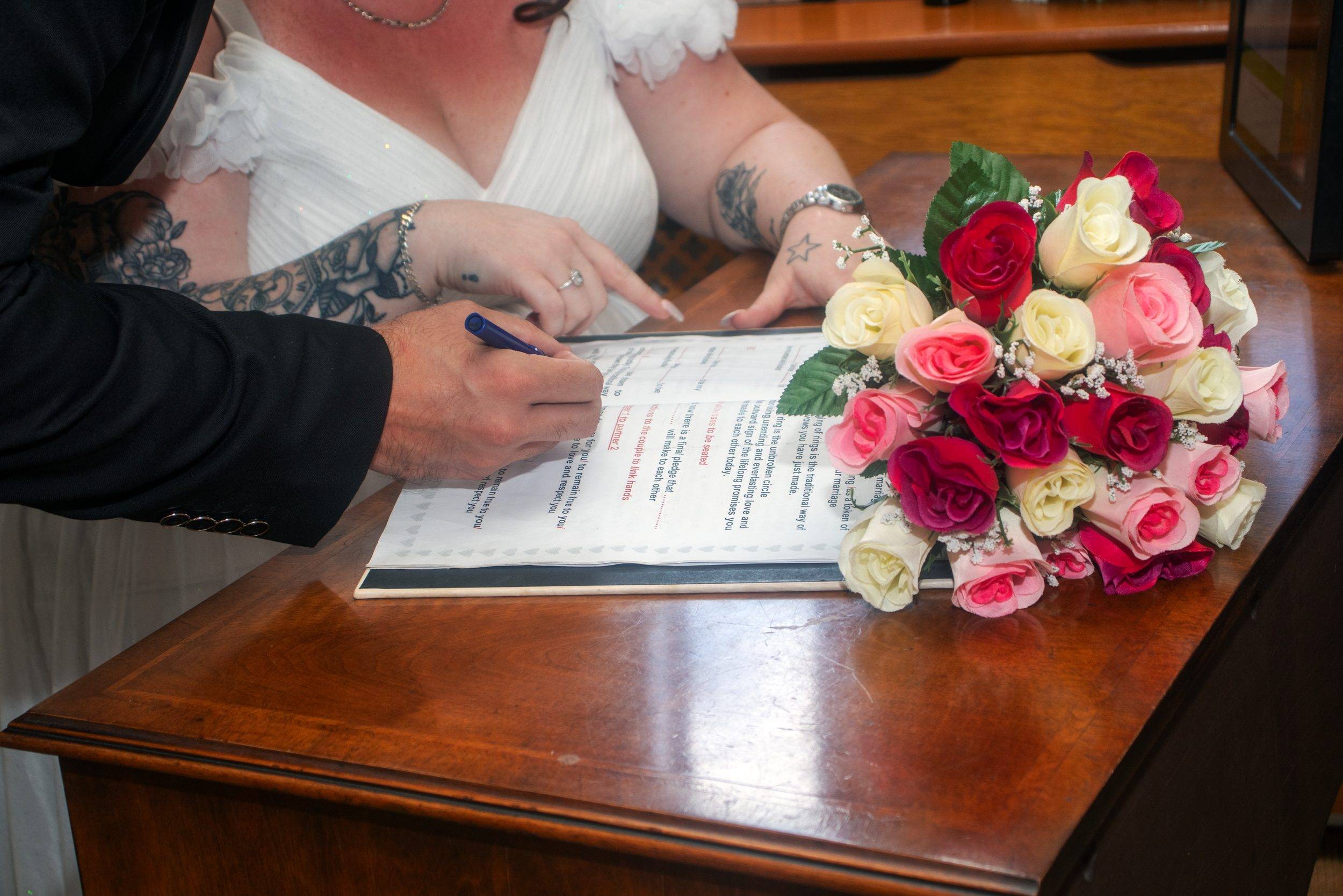 Signing the register with the bouquet on the table
