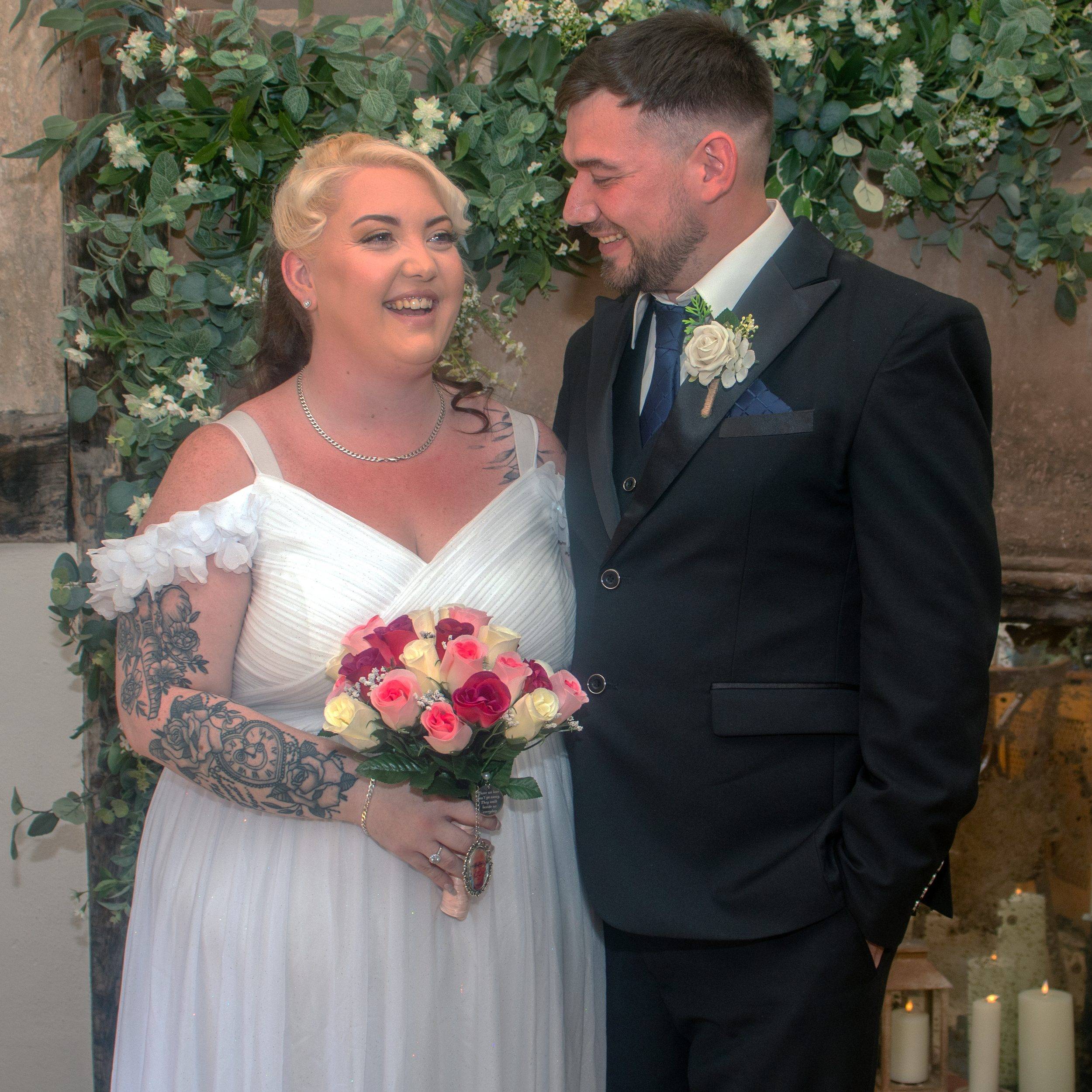 Stephen and Lauren together under the flower arch after their ceremony